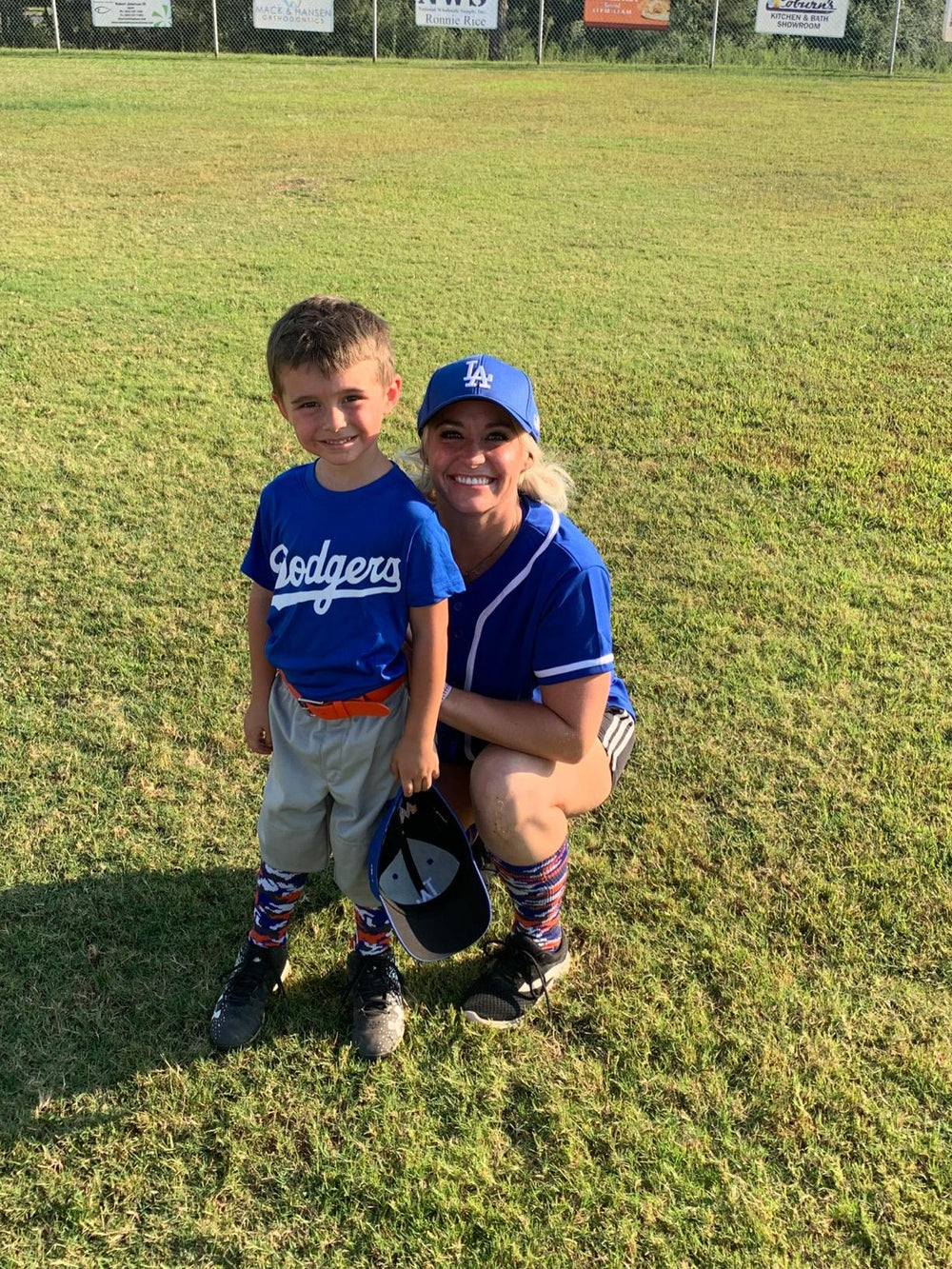 Pinkammo4x4 wearing blue jersey with child at baseball field